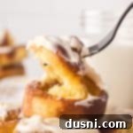 Air Fryer Cinnamon Roll Perfection 13 A fork pulling on the Air Fryer Cinnamon Roll. showing the soft fluffy inside.