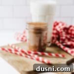 DIY Nesquik Chocolate Milk Mix 14 A Mason jar of Homemade Nesquik with a tall glass of milk behind it.