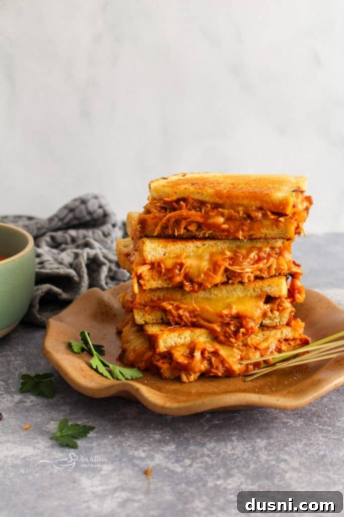 A close-up of the delicious BBQ Pulled Pork Grilled Cheese, showing the golden-brown sourdough and a peek of the pork and cheese.