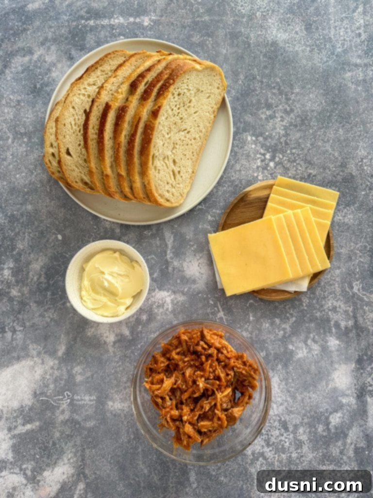 Hand holding a half of a BBQ Pulled Pork Grilled Cheese sandwich, showing the melted cheese and juicy pork.