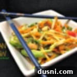 Vibrant Asian Crunch 2 Asian Slaw in a white square bowl with chopsticks laying on top and text