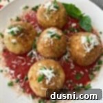 Close up of Arancini - Three Cheese Fried Risotto Balls on a white plate