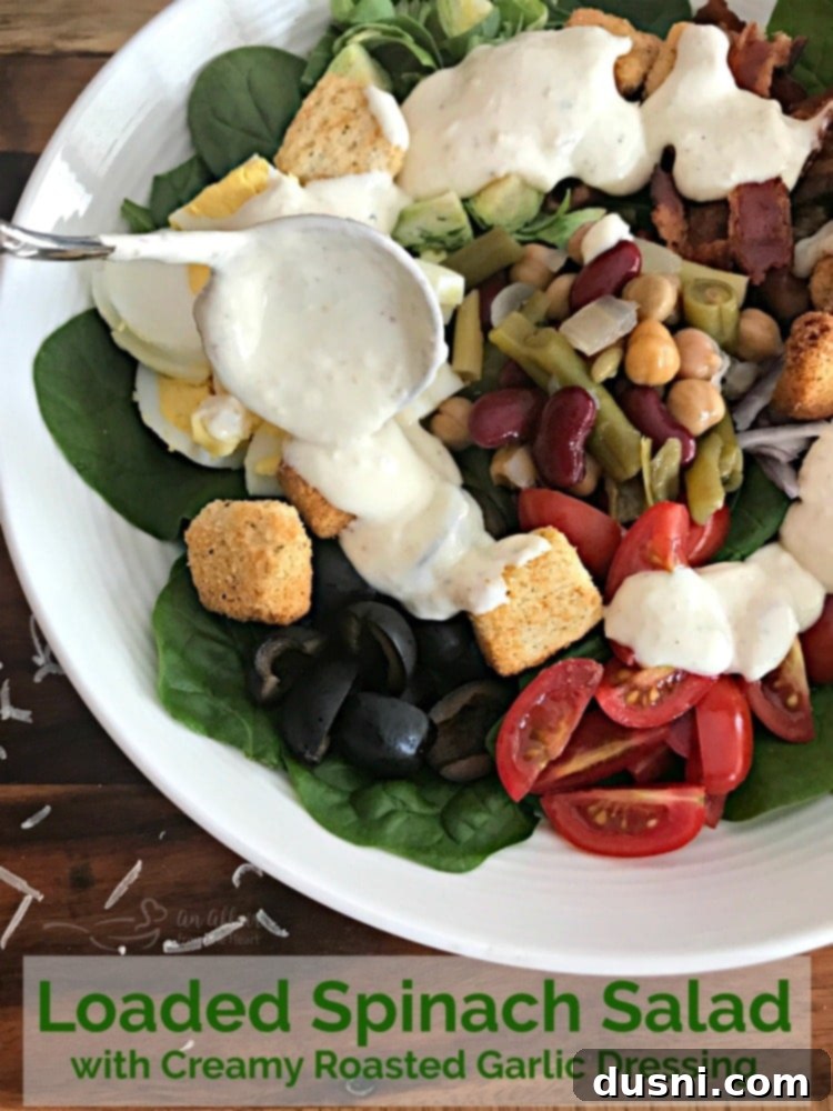 Final presentation of the Loaded Spinach Salad with Creamy Roasted Garlic Dressing