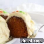 Close up of a slice of Carrot Bundt cake with cream cheese frosting on a cake server.