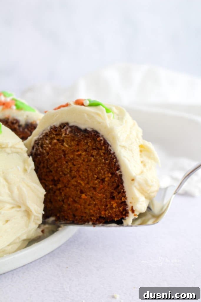 Carrot Bundt Cake with Cream Cheese Frosting, presented on a white cake stand.
