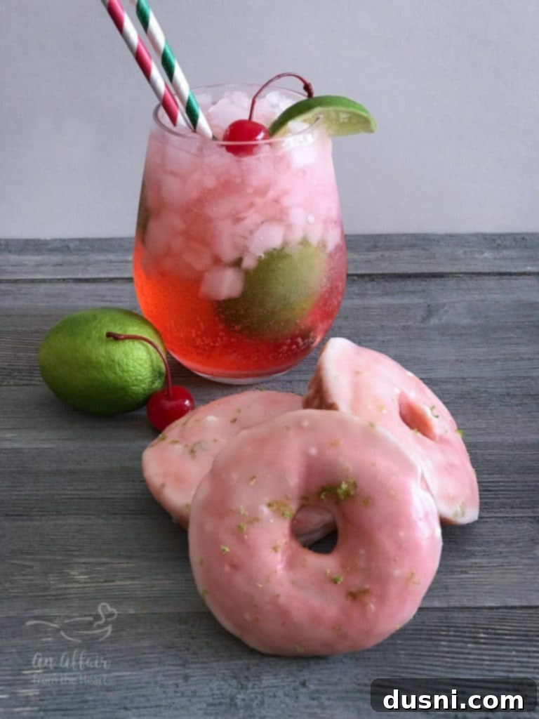 A plate of Cherry Limeade Baked Donuts next to a glass of homemade Cherry Limeade drink