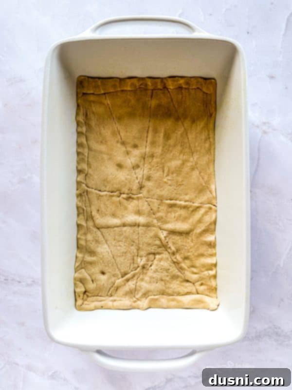 Crescent roll dough spread in a baking dish
