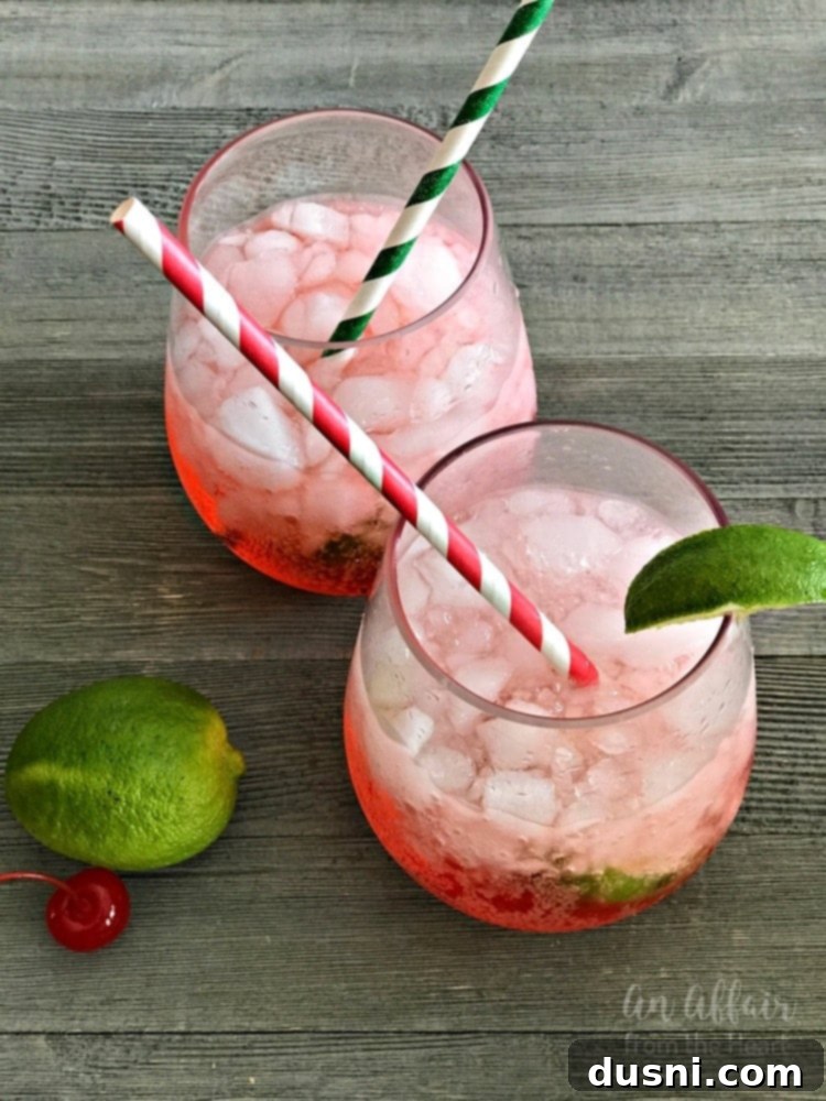 Homemade Copycat Sonic Cherry Limeade drink in a glass with a straw and lime wedges