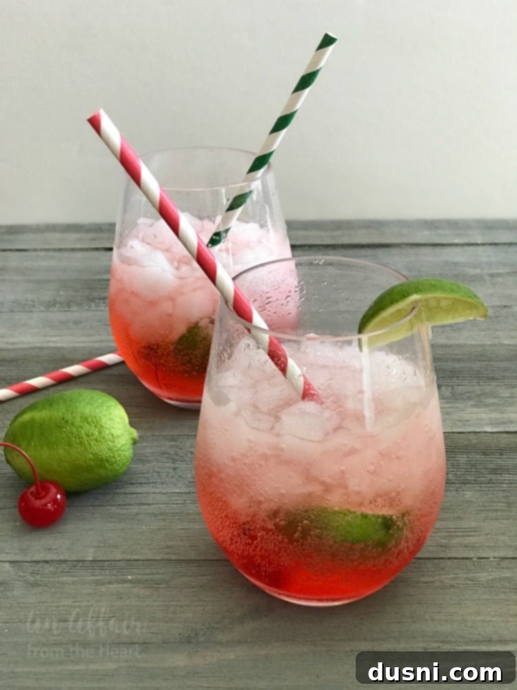Two glasses of Copycat Sonic Cherry Limeade with fresh lime and cherries