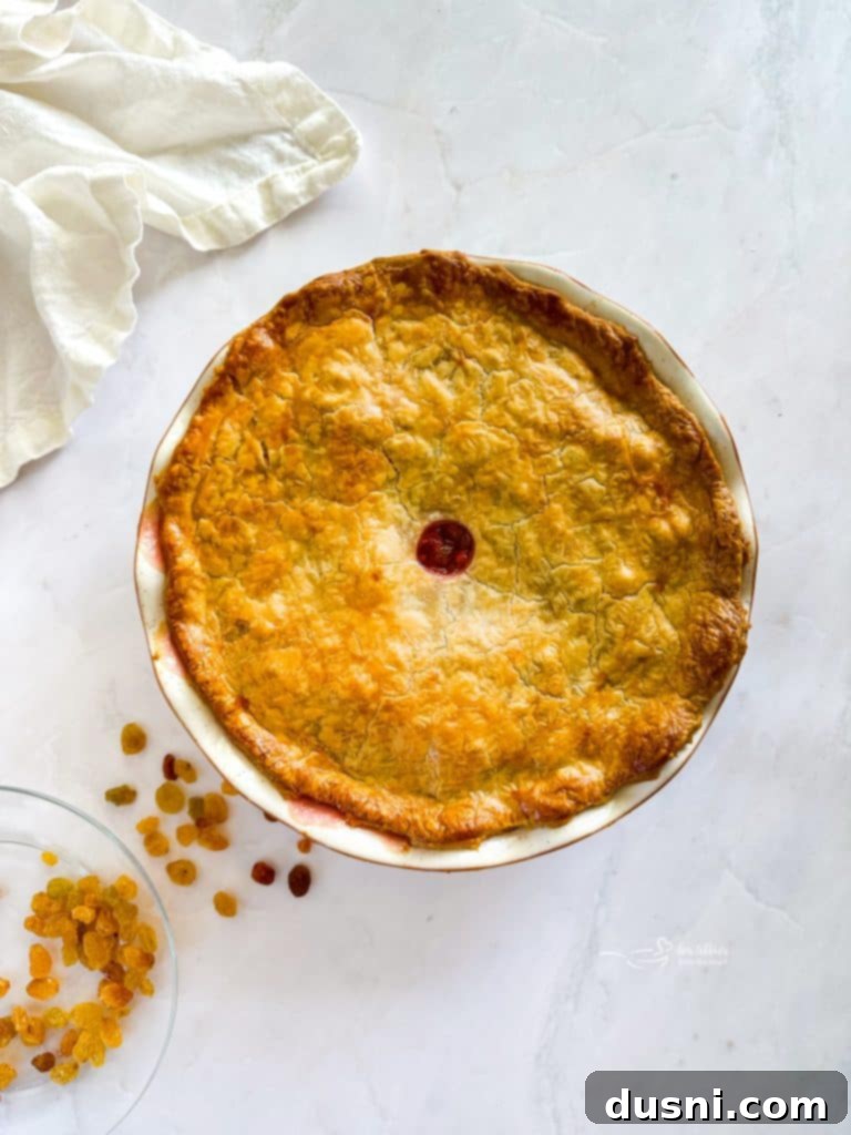 Top pie crust placed over filling, edges sealed and vented, brushed with egg wash