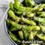Extreme close up of air fryer edamame beans in a white bowl.