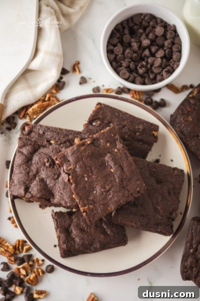 Freshly baked fudgy pecan brownies in a baking dish, with one corner piece missing.