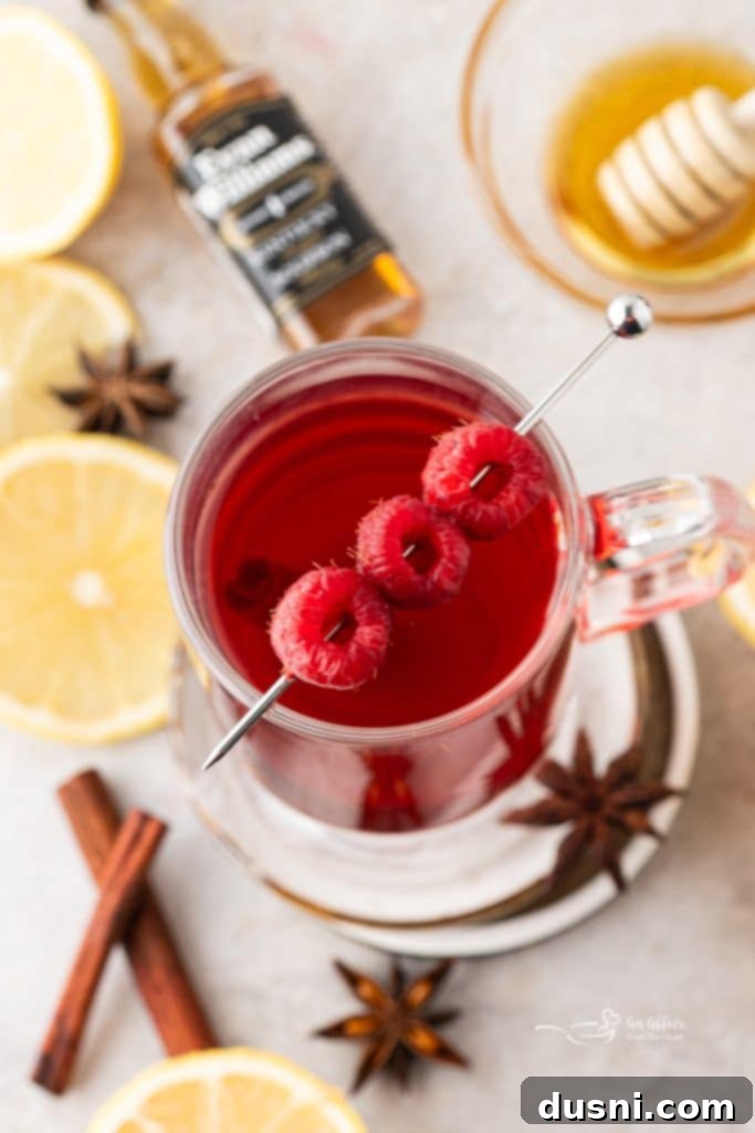 Raspberry Hot Toddy in clear glass mug with steam