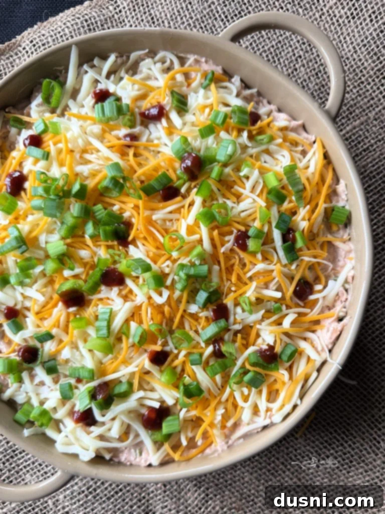 BBQ Chicken Dip with Kraut being spread into a baking dish.